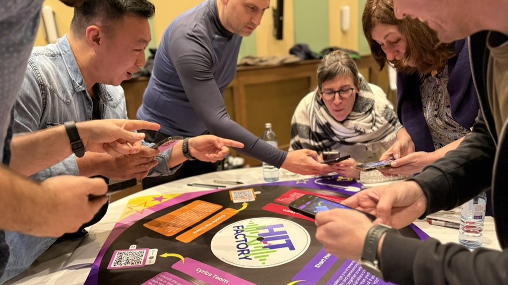Team collaborating on a creative thinking challenge during a Catalyst team building activity hit factory AI
