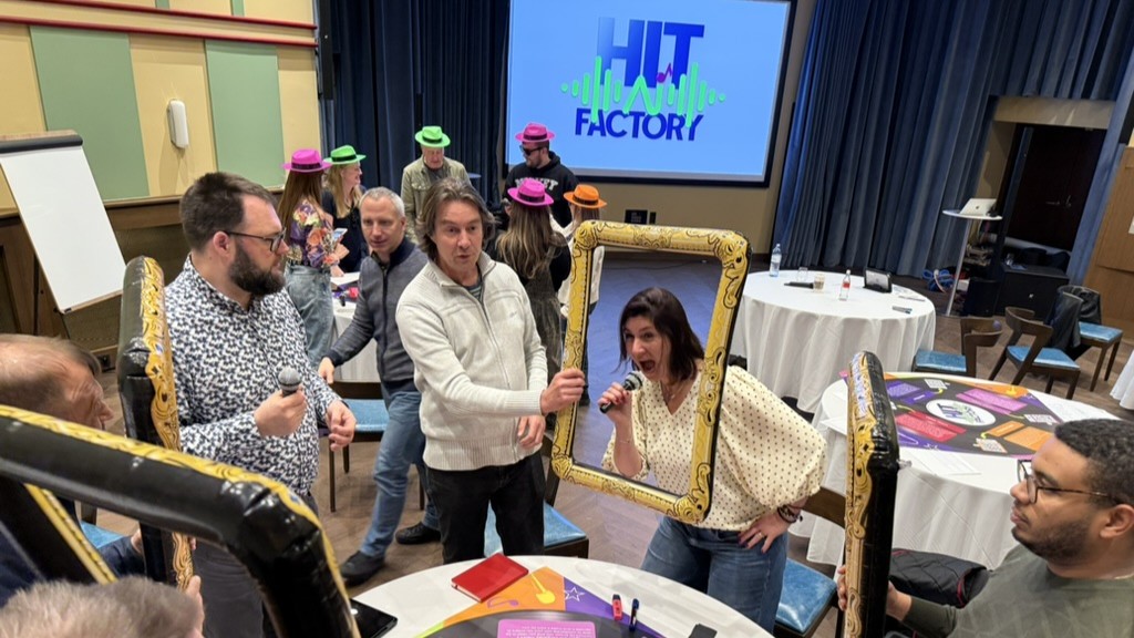 Team collaborating on a creative thinking challenge during a Catalyst team building activity hit factory AI